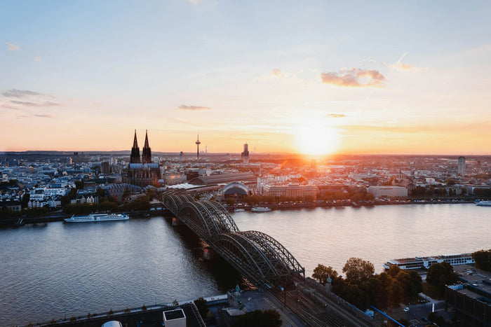 Kratom Köln – Blick über den Rhein auf den Kölner Dom und die Hohenzollernbrücke bei Sonnenuntergang