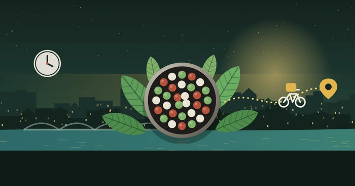Illustration: runde Schatulle mit grünen, roten und weißen Kratom-Pellets vor einer abendlichen Kölner Stadtsilhouette am Rhein, daneben ein Kurierfahrrad auf gepunkteter Route zu einem Standort-Pin